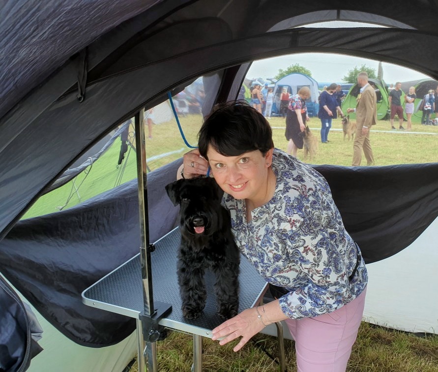 pies sznaucer miniaturowy czarny Etna z właścicielką w namiocie na wystawie